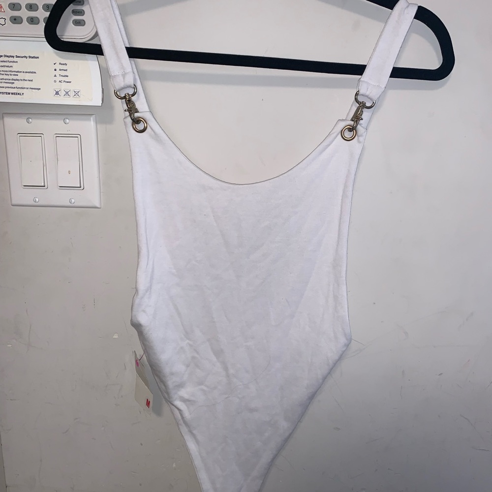 White bodysuit with snaps. Open sides on top & bottom. Chain link on strap.